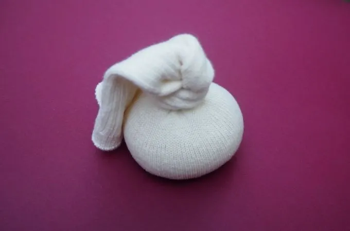 tieing a knot on a sock to make a sock doll