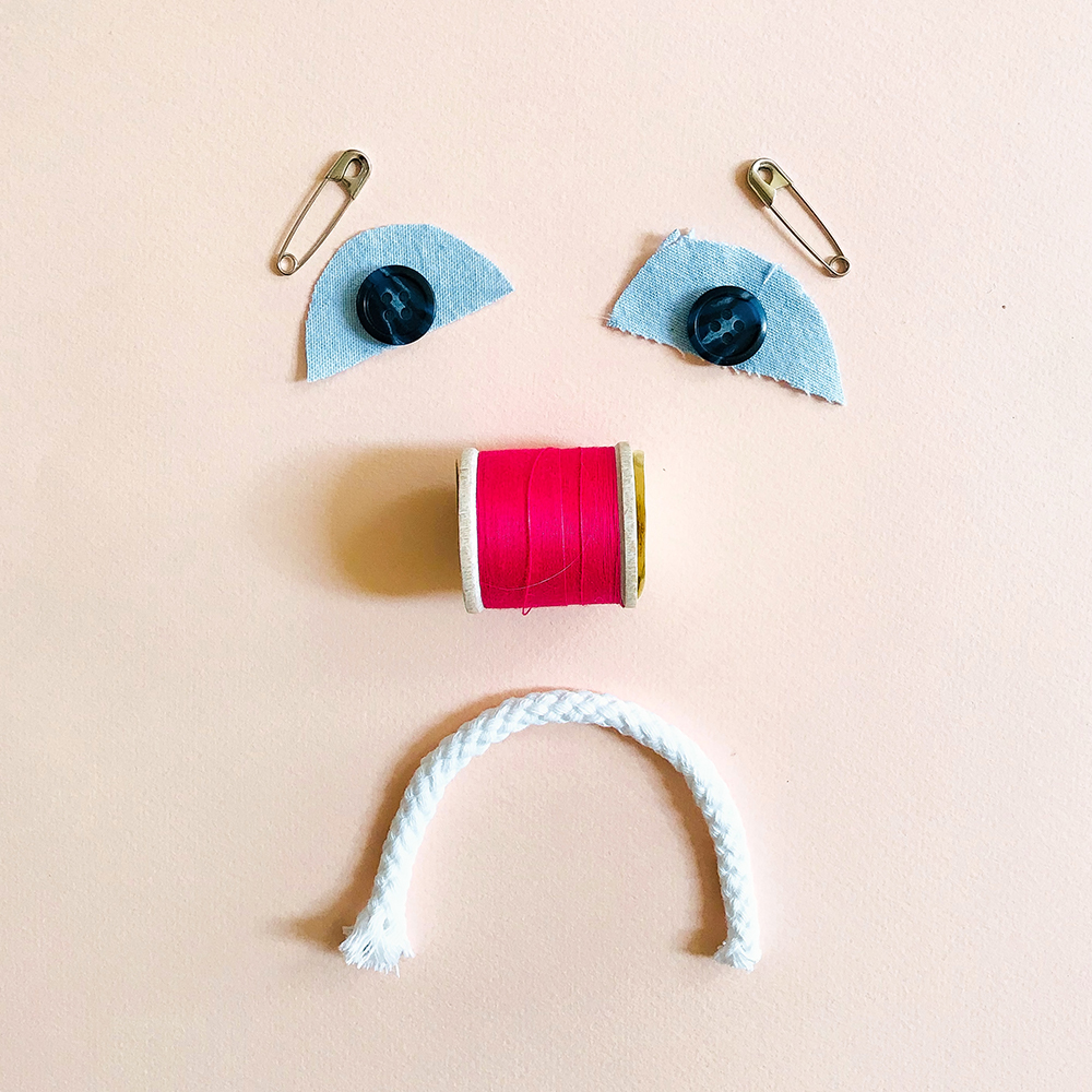 Want to Sew but Think You Can't,a sad face made from sewing supplies