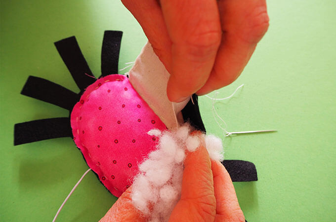 putting stuffing into a spider soft toy